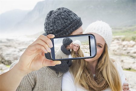 simsearch:400-07664794,k - Hand holding smartphone showing man kissing a woman on rocky landscape Stock Photo - Budget Royalty-Free & Subscription, Code: 400-07664818