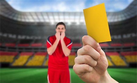 simsearch:400-07665266,k - Hand holding up yellow card against stadium full of germany football fans with player Stock Photo - Budget Royalty-Free & Subscription, Code: 400-07665265