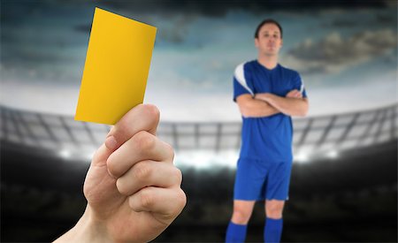 simsearch:400-07665266,k - Hand holding up yellow card against large football stadium under cloudy sky and player Stock Photo - Budget Royalty-Free & Subscription, Code: 400-07665261
