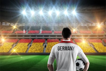 simsearch:400-07665266,k - Germany football player holding ball against stadium full of germany football fans Stock Photo - Budget Royalty-Free & Subscription, Code: 400-07665353