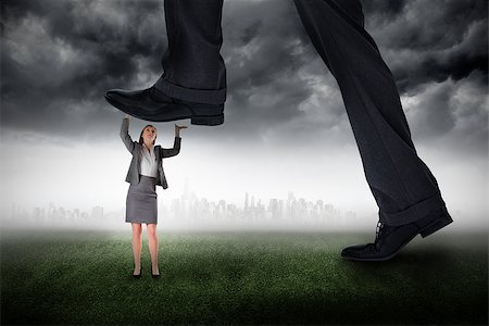 simsearch:400-07665425,k - Composite image of businessman stepping on tiny businesswoman against city on the horizon Stockbilder - Microstock & Abonnement, Bildnummer: 400-07665420