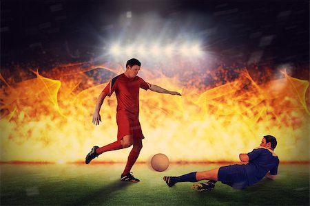 Football players tackling for the ball against football pitch under spotlights Stock Photo - Budget Royalty-Free & Subscription, Code: 400-07665478