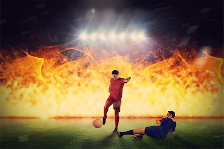 Football players tackling for the ball against football pitch under spotlights Stock Photo - Budget Royalty-Free & Subscription, Code: 400-07665480
