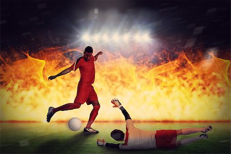 Football players tackling for the ball against football pitch under spotlights Stock Photo - Budget Royalty-Free & Subscription, Code: 400-07665482