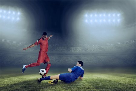 simsearch:400-07665266,k - Football players tackling for the ball against large football stadium under blue sky Stock Photo - Budget Royalty-Free & Subscription, Code: 400-07665507