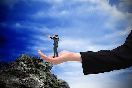 Businessman looking through telescope in hand against large rock overlooking bright blue sky Stock Photo - Budget Royalty-Free & Subscription, Code: 400-07665559