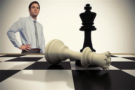 simsearch:400-07665425,k - Composite image of serious businessman with hand on hip with chessboard Stockbilder - Microstock & Abonnement, Bildnummer: 400-07665707