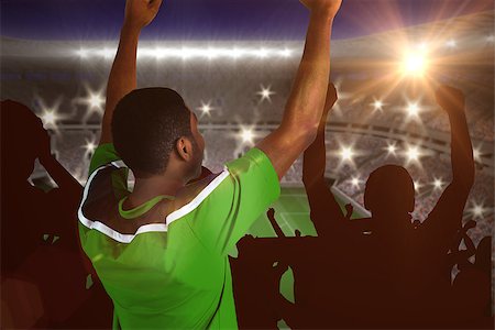 simsearch:400-07665266,k - Cheering football fan in green jersey against large football stadium with lights Stock Photo - Budget Royalty-Free & Subscription, Code: 400-07665812