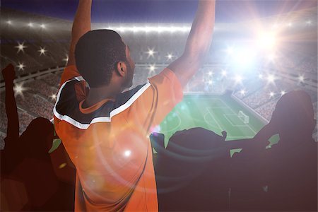 simsearch:400-07665266,k - Cheering football fan in orange jersey against large football stadium with lights Stock Photo - Budget Royalty-Free & Subscription, Code: 400-07665813