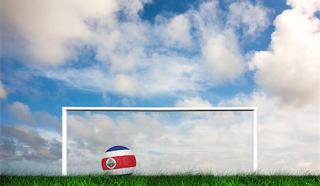 Football in costa rica colours against green grass under dark blue and orange sky Stock Photo - Budget Royalty-Free & Subscription, Code: 400-07665881