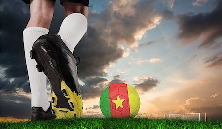 Composite image of football boot kicking cameroon ball against green grass under blue and orange sky Stock Photo - Budget Royalty-Free & Subscription, Code: 400-07666008