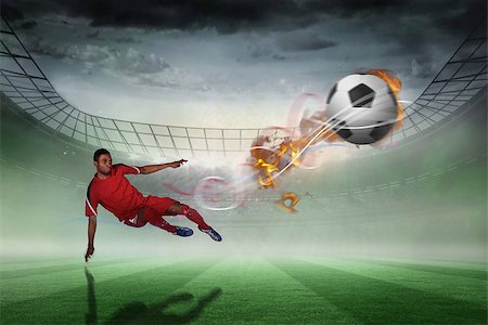 simsearch:400-07665266,k - Football player in red kicking against misty football stadium under spotlights Stock Photo - Budget Royalty-Free & Subscription, Code: 400-07666161