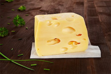 emmentaler cheese - Big emmentaler piece on dark wooden background with chive and parsley in background. Stock Photo - Budget Royalty-Free & Subscription, Code: 400-07667173