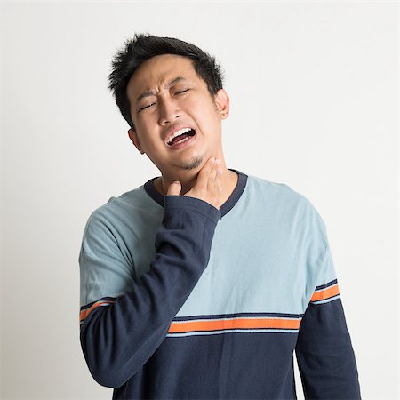 Asian male sore throat with painful face expression, on plain background Stock Photo - Budget Royalty-Free & Subscription, Code: 400-07667609