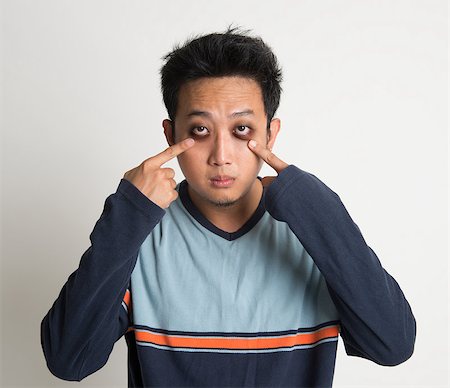eye pointing - Asian man insomnia, with big eyes bag, on plain background Stock Photo - Budget Royalty-Free & Subscription, Code: 400-07667600