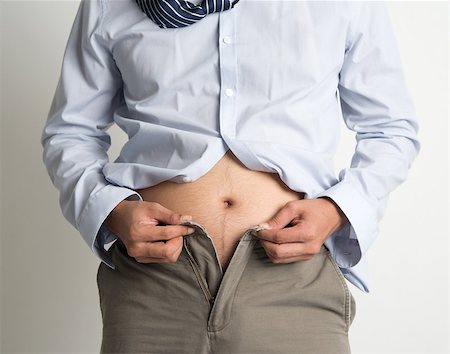 simsearch:400-06178010,k - Middle age man with big belly unable to close the pants due to gaining weight, on plain background. Stock Photo - Budget Royalty-Free & Subscription, Code: 400-07667618