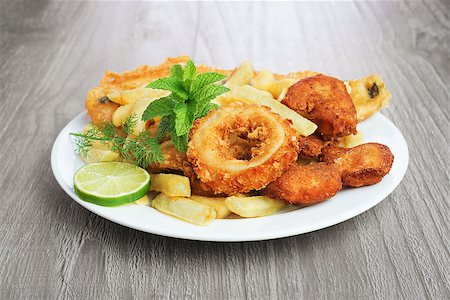 Seafood dish with crumbed fish,calamari,prawn and potato chips on vintage table Foto de stock - Royalty-Free Super Valor e Assinatura, Número: 400-07667685