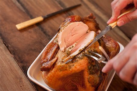 stockarch (artist) - Overhead view of the hands of a man carving a roast turkey with a carving knife and fork slicing the breast meat ready for a Thanksgiving or Christmas dinner Foto de stock - Royalty-Free Super Valor e Assinatura, Número: 400-07668482