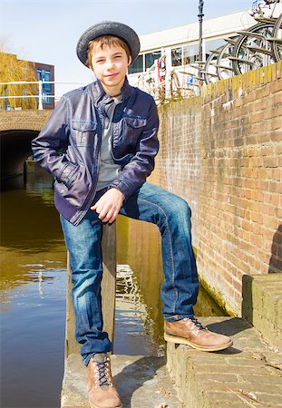Cute teenage boy in hat (full-length portrait) against canal background Stock Photo - Budget Royalty-Free & Subscription, Code: 400-07668756