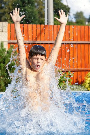 Boy jumping in the home garden swimming pool with clear water Stock Photo - Budget Royalty-Free & Subscription, Code: 400-07669827