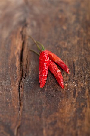 dry red chili peppers over old wood table Photographie de stock - Aubaine LD & Abonnement, Code: 400-07661575