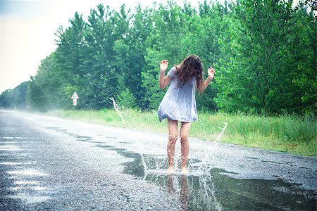 reflection in puddle - Beautiful girl jumps in a puddle on the road Stock Photo - Budget Royalty-Free & Subscription, Code: 400-07661595