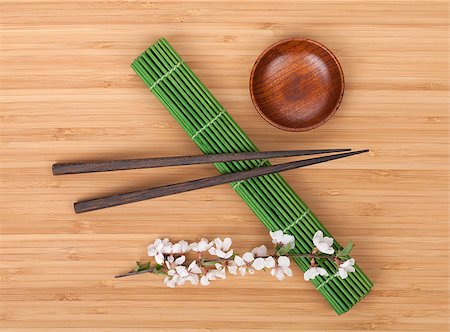 simsearch:400-07719212,k - Chopsticks and sakura branch over bamboo mat Fotografie stock - Microstock e Abbonamento, Codice: 400-07662733