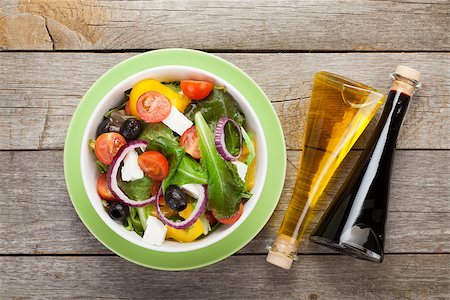 Fresh healthy greek salad and condiment bottles on wooden table background Stock Photo - Budget Royalty-Free & Subscription, Code: 400-07662757