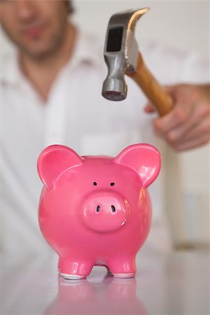 Casual businessman breaking piggy bank with hammer in his office Stock Photo - Budget Royalty-Free & Subscription, Code: 400-07662875