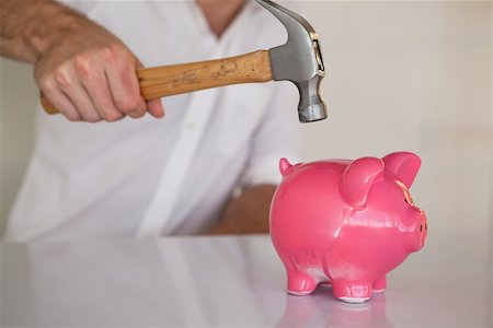 Casual businessman breaking piggy bank with hammer in his office Stock Photo - Budget Royalty-Free & Subscription, Code: 400-07662876