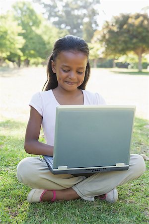 simsearch:400-06890095,k - Little girl sitting on grass using laptop on a sunny day Stock Photo - Budget Royalty-Free & Subscription, Code: 400-07663659