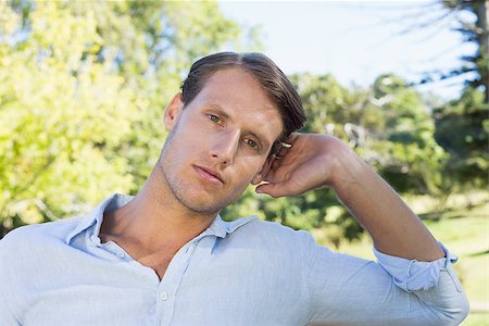 simsearch:400-07778671,k - Handsome man frowning at camera in the park on a sunny day Fotografie stock - Microstock e Abbonamento, Codice: 400-07663675