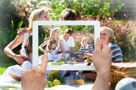 simsearch:400-07664794,k - Hand holding tablet pc showing happy family having a picnic Stock Photo - Budget Royalty-Free & Subscription, Code: 400-07663989