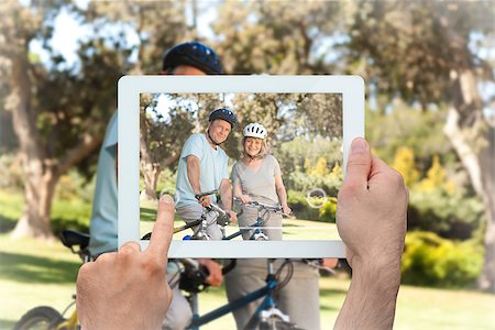 simsearch:400-07664794,k - Hand holding tablet pc showing elderly couple with their bikes Stock Photo - Budget Royalty-Free & Subscription, Code: 400-07663994