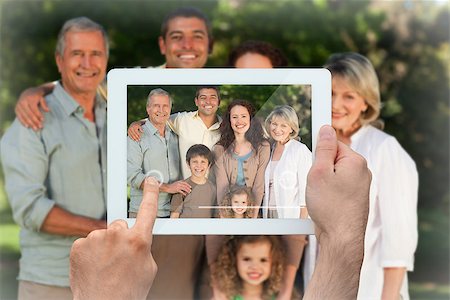 simsearch:400-07664794,k - Hand holding tablet pc showing family looking at the camera in the park Stock Photo - Budget Royalty-Free & Subscription, Code: 400-07663995