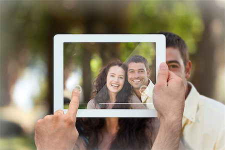 simsearch:400-07664794,k - Hand holding tablet pc showing couple sitting in the garden Stock Photo - Budget Royalty-Free & Subscription, Code: 400-07663996