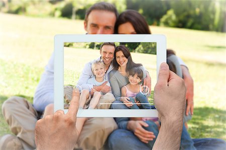 family with tablet in the park - Hand holding tablet pc showing family sitting in the park Stock Photo - Budget Royalty-Free & Subscription, Code: 400-07663990