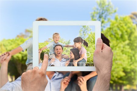 family with tablet in the park - Hand holding tablet pc showing parents giving children a piggyback Photographie de stock - Aubaine LD & Abonnement, Code: 400-07663991