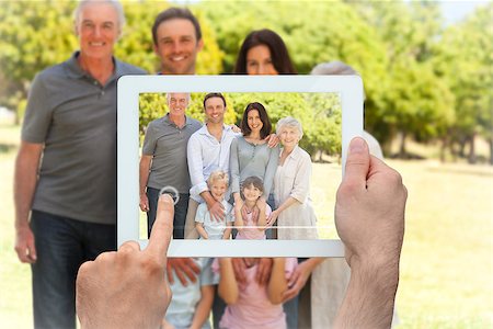 family tablet pc - Hand holding tablet pc showing family standing in the park Photographie de stock - Aubaine LD & Abonnement, Code: 400-07663992
