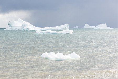 Beautiful icebergs in the sun and in front of a dark sky Stock Photo - Budget Royalty-Free & Subscription, Code: 400-07675614