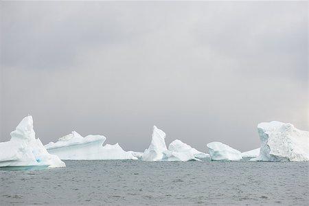 Beautiful icebergs in the sun and in front of a dark sky Stock Photo - Budget Royalty-Free & Subscription, Code: 400-07675615