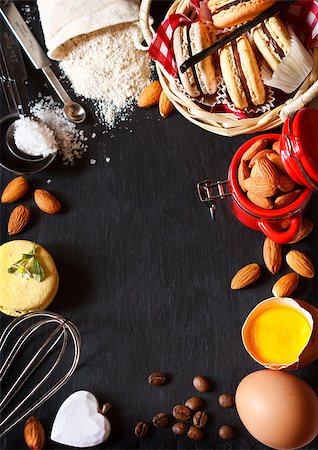 Baking frame. Sweet macarons cookies and food ingtedients for baking on a black slate board with copy space for recipe. Stockbilder - Microstock & Abonnement, Bildnummer: 400-07675915