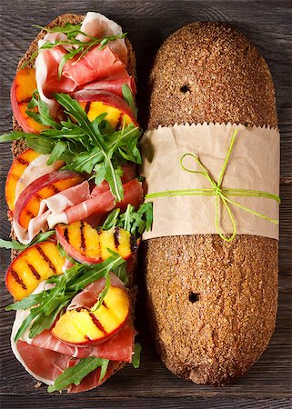 simsearch:400-07792940,k - Delicious ham sandwich with grilled peaches and arugula on an wooden background. Stock Photo - Budget Royalty-Free & Subscription, Code: 400-07675962