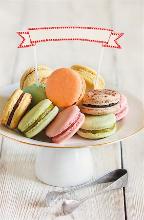 Fresh sweet macarons on a cake stand with empty decorative name tag. Toned photo. Vintage style. Photographie de stock - Aubaine LD & Abonnement, Code: 400-07675984