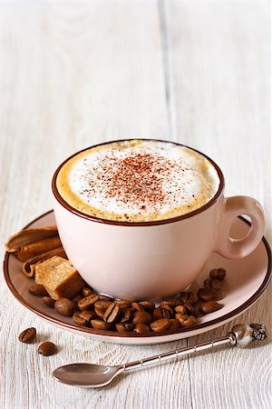 simsearch:824-07562793,k - Cup of fresh cappuccino coffee with coffee beans, brownsugar and cinnamon sticks close-up. Photographie de stock - Aubaine LD & Abonnement, Code: 400-07675981