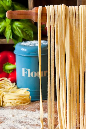 simsearch:400-05878972,k - Fresh homemade pasta hanging on wooden rolling pin close-up. Stockbilder - Microstock & Abonnement, Bildnummer: 400-07676000