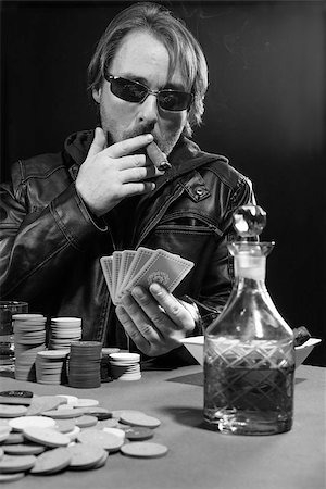 simsearch:400-06136085,k - Photo of a man playing poker while wearing sunglasses and smoking a cigar. Fotografie stock - Microstock e Abbonamento, Codice: 400-07676486