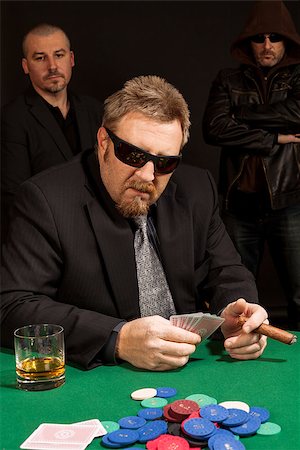 simsearch:400-06136085,k - Photo of a man playing poker while wearing sunglasses and smoking a cigar. Fotografie stock - Microstock e Abbonamento, Codice: 400-07676487