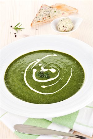 simsearch:400-07298426,k - Spinach soup in white plate on wooden table, toast bread and herbal butter in bowl in background. Stock Photo - Budget Royalty-Free & Subscription, Code: 400-07677137