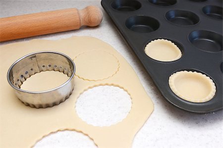 simsearch:400-07677933,k - Lining a bun tin with circles of rolled out pastry to make mince pies, with a rolling pin on the worktop Stock Photo - Budget Royalty-Free & Subscription, Code: 400-07677934
